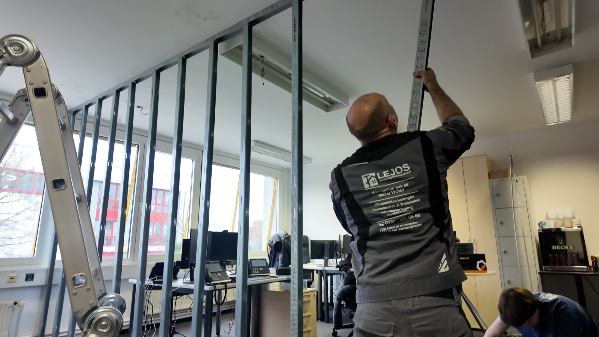 Monteur der LEJOS Sanierungshelden misst ein Metallständerwerk für eine neue Trennwand ein